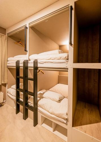 a hostel with bunk beds in a room at Rusutsu Grand Cabin in Kimobetsu
