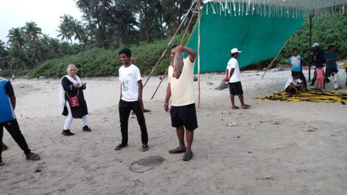 a group of people standing on a beach at Samant Beach Resort in Malvan