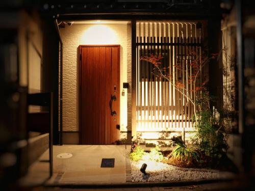 a front door of a house with a bird in front at 萱の小築 in Kyoto
