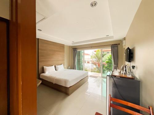 a bedroom with a bed and a large window at Tachang Airport Hotel in Hat Yai