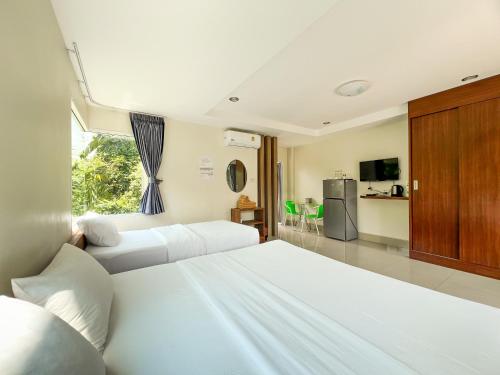 a bedroom with two beds and a kitchen at Tachang Airport Hotel in Hat Yai