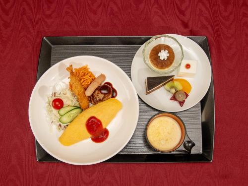 a tray with two plates of food on a table at R Hotels Inn Hokkaido Asahikawa in Asahikawa