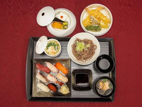 a tray of food with vegetables and other foods at R Hotels Inn Hokkaido Asahikawa in Asahikawa
