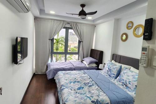 a bedroom with two beds and a window at Near Ferry Terminal - Lovely 2 Bedroom Condo - Harbourbay Residences - 0608 in Tanjunguma
