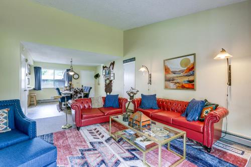 a living room with red couches and a table at Carbondale Condo with Balcony and On-Site Fly Fishing! in Carbondale