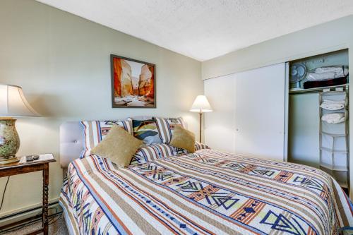 a bedroom with a bed with a colorful comforter at Carbondale Condo with Balcony and On-Site Fly Fishing! in Carbondale