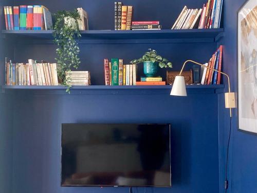 a blue wall with a shelf with books at T2 lumineux - rénové- - Centre historique Dinan- Parking - Terrasse in Dinan