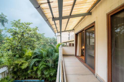 a balcony of a house with a view of trees at ELIVAAS 4 BHK with Pvt & Outdoor Sitting Area - Anasa in Goa