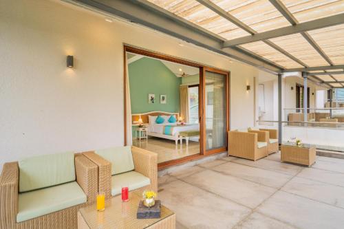 a living room with chairs and a room with a couch at ELIVAAS 4 BHK with Pvt & Outdoor Sitting Area - Anasa in Goa