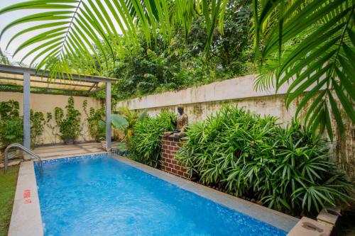 a swimming pool in the backyard of a house at ELIVAAS 4 BHK with Pvt & Outdoor Sitting Area - Anasa in Goa