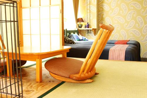 a wooden chair and a table in a room at Minamiboso Asian Garden Villa Shirahama in Minamiboso