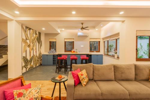 a living room with a couch and a kitchen at ELIVAAS 4 BHK with Pvt & Outdoor Sitting Area - Anasa in Goa