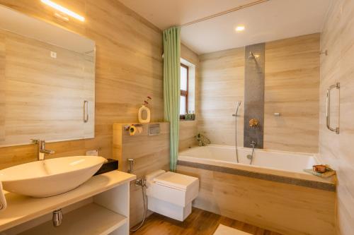 a bathroom with a sink and a tub and a toilet at ELIVAAS 4 BHK with Pvt & Outdoor Sitting Area - Anasa in Goa