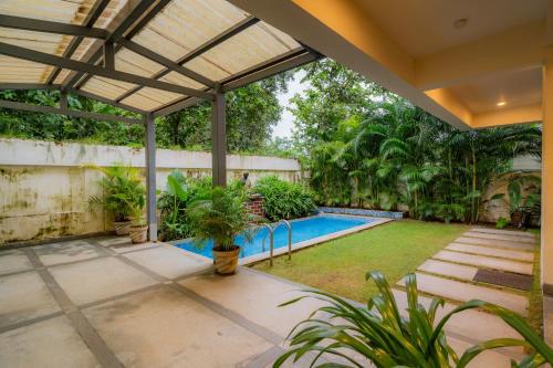 an image of a swimming pool in a house at ELIVAAS 4 BHK with Pvt & Outdoor Sitting Area - Anasa in Goa