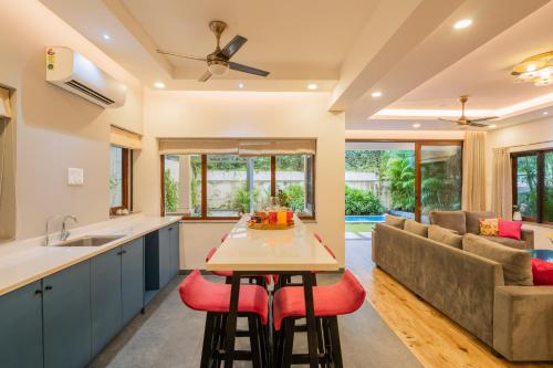 a kitchen and living room with a table and a couch at ELIVAAS 4 BHK with Pvt & Outdoor Sitting Area - Anasa in Goa