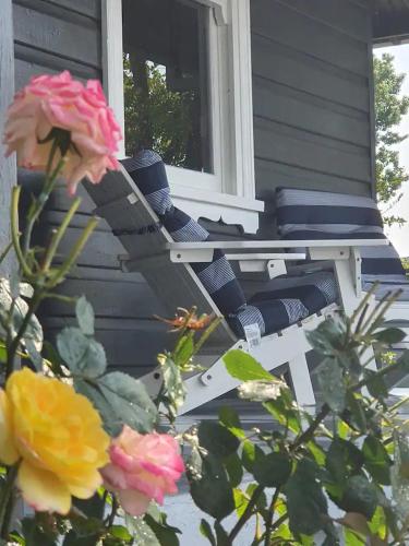 a porch with a chair and flowers on a house at Ellson House - The Heart of the Hunter in Cessnock