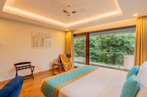 a bedroom with a bed and a large window at ELIVAAS 4 BHK with Pvt & Outdoor Sitting Area - Anasa in Goa