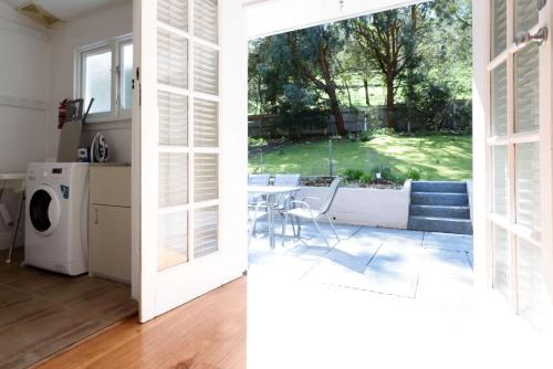a kitchen with a door open to a yard at The Basin Cottage in Royal Park