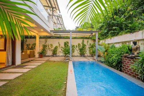 a swimming pool in the backyard of a house at ELIVAAS 4 BHK with Pvt & Outdoor Sitting Area - Anasa in Goa
