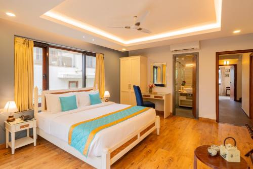 a bedroom with a large white bed and a desk at ELIVAAS 4 BHK with Pvt & Outdoor Sitting Area - Anasa in Goa