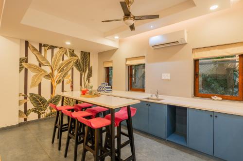 a kitchen with blue cabinets and red stools at ELIVAAS 4 BHK with Pvt & Outdoor Sitting Area - Anasa in Goa