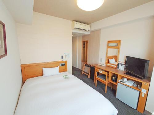 a hotel room with a bed and a desk at Hotel Route-Inn Shibata Inter in Shibata