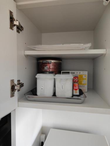 a refrigerator with three containers of food on a shelf at 4BRHouse near Nikko Suginami Cedar Avenue in Nikko