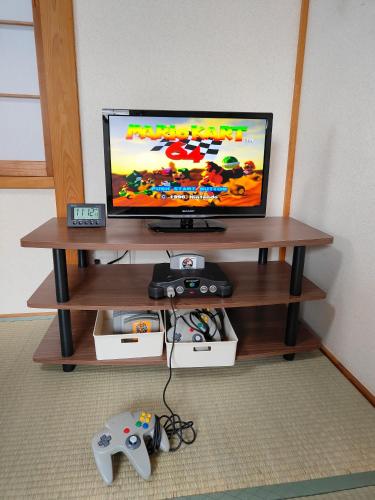 a tv sitting on a table with a video game controller at 4BRHouse near Nikko Suginami Cedar Avenue in Nikko