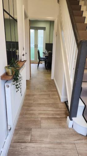 a hallway of a house with a staircase and a table at Beautifully Fab 3 bedroom 7 guests house in Farnworth