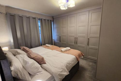 a bedroom with a large bed with white sheets at Beautifully Fab 3 bedroom 7 guests house in Farnworth