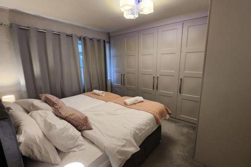 a bedroom with a bed with white sheets and pillows at Beautifully Fab 3 bedroom 7 guests house in Farnworth