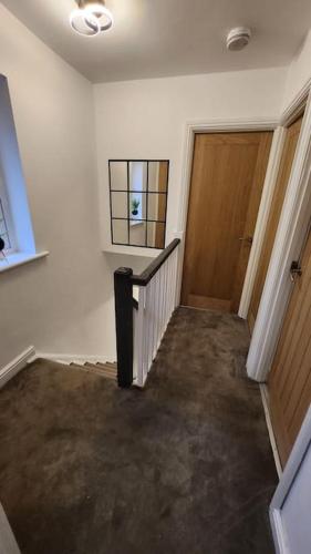 a hallway with a staircase and a door in a house at Beautifully Fab 3 bedroom 7 guests house in Farnworth