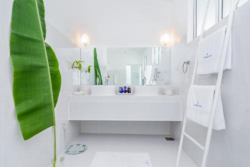 a white bathroom with a sink and a mirror at Tea Heights and Spa in Kandy