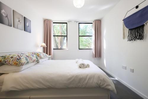 a white bedroom with a bed with a stuffed animal on it at Modern Comfort Near Castle St with WiFi & Parking! in Taunton