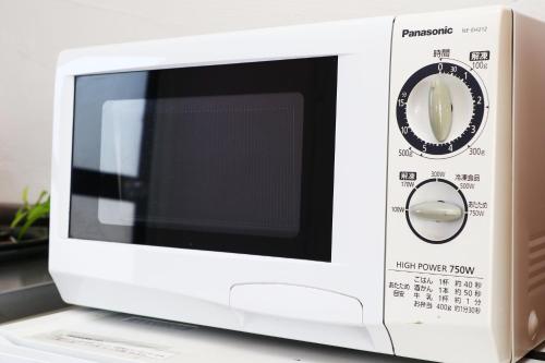 a white microwave oven sitting on top of a counter at Minamiboso Asian Garden Villa Shirahama in Minamiboso