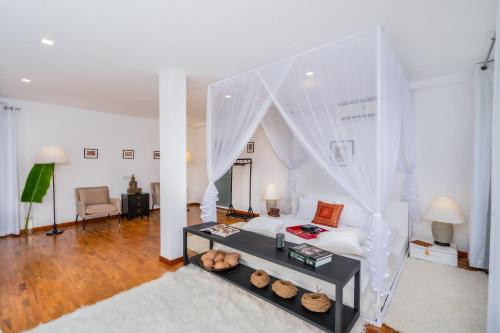 a white living room with a bed and a table at Tea Heights and Spa in Kandy
