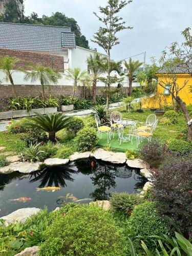a garden with a pond with chairs and a table at Plum Village Moc Chau in Mộc Châu