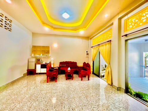 un soggiorno con sedie rosse e un tavolo di สบาย สบายโฮมสเตย์เบตง Sabai Sabai Homestay Betong a Betong