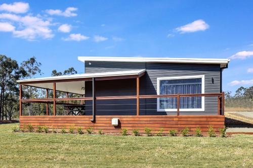 una casa pequeña con un porche envolvente en Magpie Three- Two for Joy Estate. 2.5 Bathrooms sleeping 6, en Greta