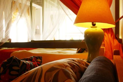 a person sitting on a couch with a lamp at Minamiboso Asian Garden Villa Shirahama in Minamiboso