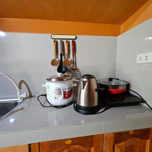 a kitchen counter with a coffee maker and utensils at Casa Celine Dumaguete in Dumaguete