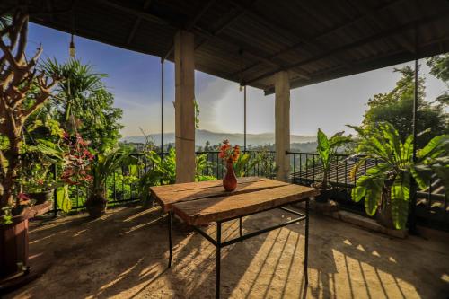 una mesa de madera con un jarrón en la parte superior de un balcón en Cielo Residence, en Kandy