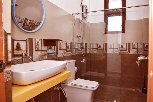 a bathroom with a sink and a toilet and a mirror at Travel Neth Holidays Bungalow Anuradhapuraya in Anuradhapura
