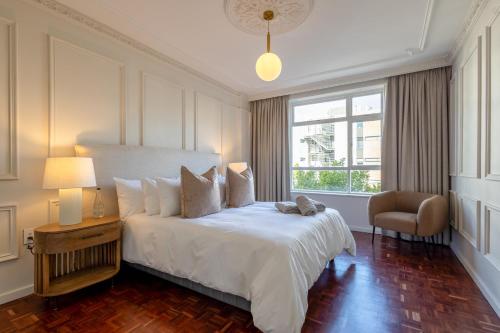 a bedroom with a large white bed and a window at 201 Cascades l 2 Bed Boutique Aparthotel in Cape Town