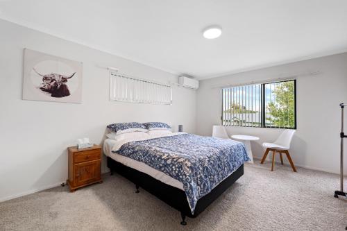 a bedroom with a bed and a table and a window at Fernwood Escape - Tauranga Holiday Home in Tauranga