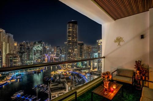 a balcony with a view of the city at night at Elite Waterfront 3BR Haven - Marina and Sea Views! in Dubai