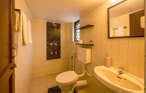 a bathroom with a toilet and a sink at Olive Zip Calangute Mira by Embassy Group in Calangute