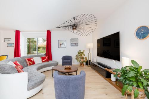 un salon avec un canapé et une télévision dans l'établissement CALME et DETENTE en famille ou entre amis, à Poilley