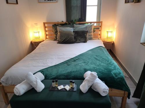 a bedroom with a bed with towels on a table at Le Pont Ravet in Bernay