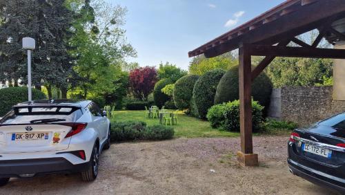 a car parked under a pergola in a yard at Hôtel Saint Jacques in Thorigné-sur-Dué